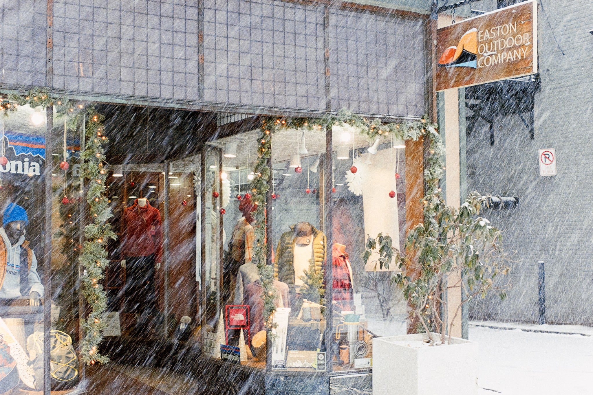 Storefront with mannequins and winter clothing in a snowy setting